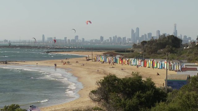 WS Brighton Beach with beach huts and kite surfers, downtown skyline in background / Melbourne, Australia