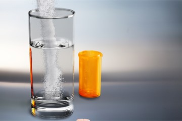 Pouring powder on water glass on  background