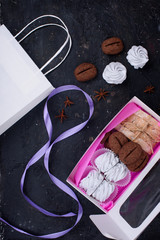 Delicious gift sets of marshmallow, cookies with taste and frma ko, biscotti. Desserts in beautiful packaging. Black background