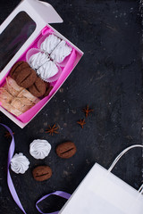 Delicious gift sets of marshmallow, cookies with taste and frma ko, biscotti. Desserts in beautiful packaging. Black background