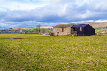 Fototapeta na wymiar Wensleydale Stone Barn. Stone barn in Wensleydale, Stone barns are common through the NorthYorkshire, dales situated in the small dry-stone walled fields.