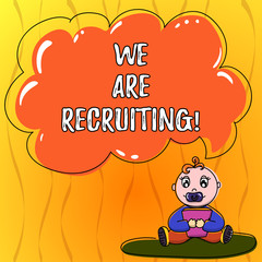 Fototapeta premium Text sign showing We Are Recruiting. Conceptual photo get someone to join something like community or job Baby Sitting on Rug with Pacifier Book and Blank Color Cloud Speech Bubble