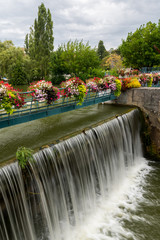 The weir of Kir lake with beautiful flowers on a cloudy day in summer