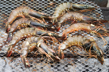 Roasted prawns on metal baking sheet background close up