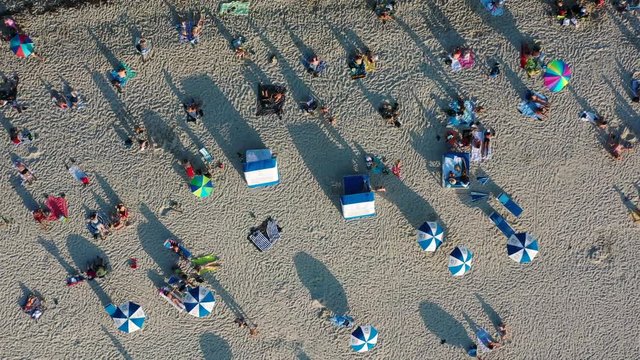 Looking down on a beach full of people and zooming out