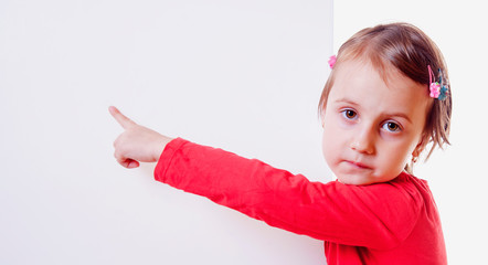Banner with a little cute child girl pointing her finger towards copy space area.