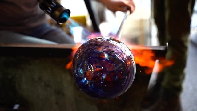 A Beautiful piece of glass art being created by a glass blower using a torch