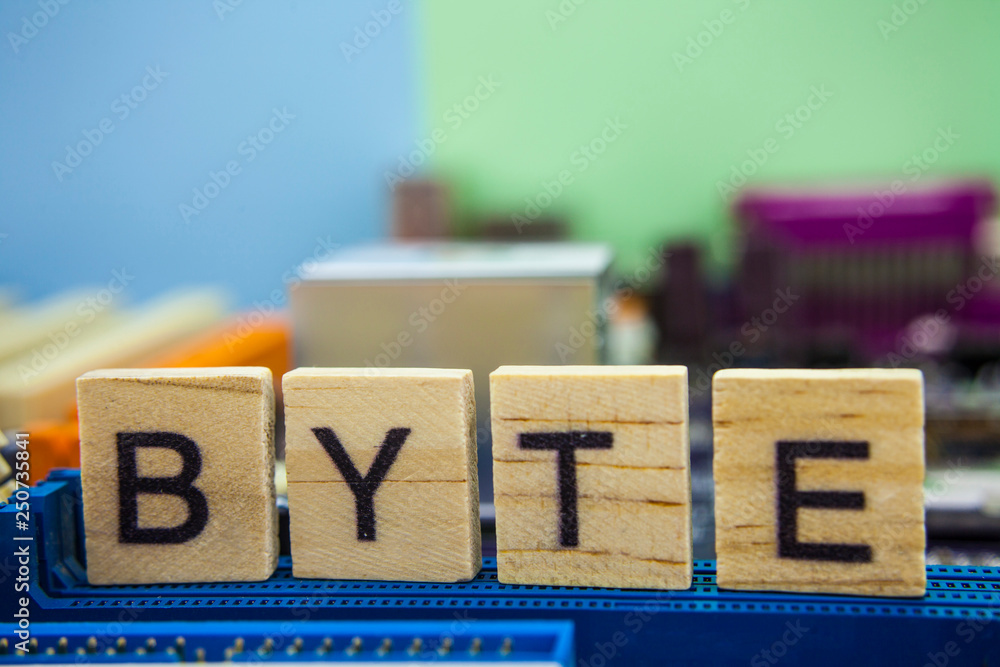 Fototapete word byte on the wooden blocks with computers mainboard background. information technology backgroun
