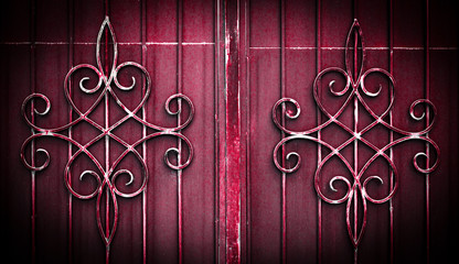 .Wrought iron gate flower like custom made ornament on dark red metal plate