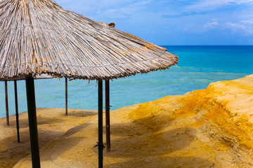 Beach at sea with canyon and sandy beach. Plastic seats on the sandy beach. Holiday concept with beach and sea in the background