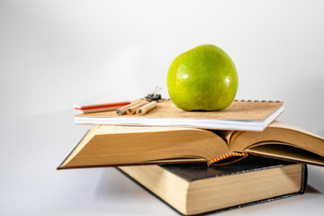Books and apple on white background.