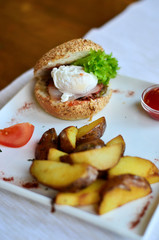 fried potatoes sliced with burger and poached egg with sauce