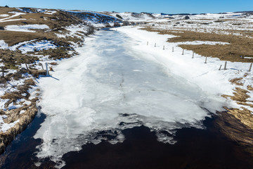 Le lit d'une rivière glacée dans un nature enneigée