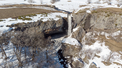 vue aérienne sur une cascade en hiver dans la campagne enneigée