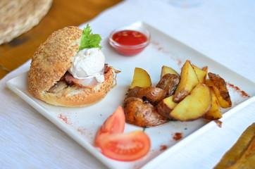 fried potatoes sliced with burger and poached egg with sauce