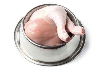 Raw, natural chicken pet food in metal bowl, isolated on white background.