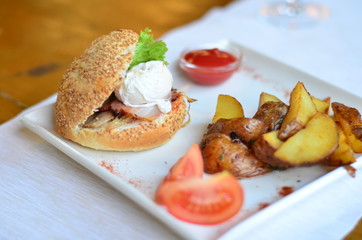fried potatoes sliced with burger and poached egg with sauce