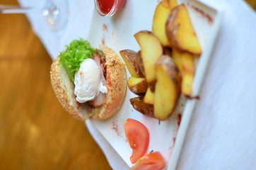 fried potatoes sliced with burger and poached egg with sauce