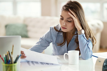 Young businesswoman analyzing business reports in the office.