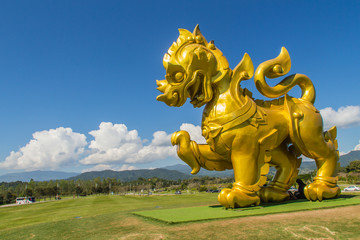 Golden lion statue logo under blue sky and white clouds background at Boonrod farm or singha park,...
