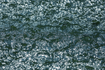 small waves on the surface of the water, falling streams of the fountain create a splash and drops