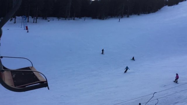 Snowboarder falls on a slope among skiers and other snowboarders