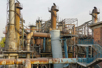 Old Factory metal structures. Industrial plant with old, rusty pipes and cooling tower for cooling water supply. Beijing, China.