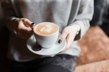 Cup of cappuchino in hands