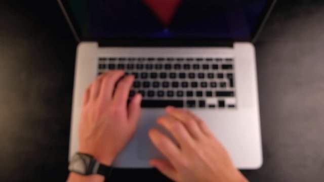 Overhead view of man hands typing on his laptop on blurred background