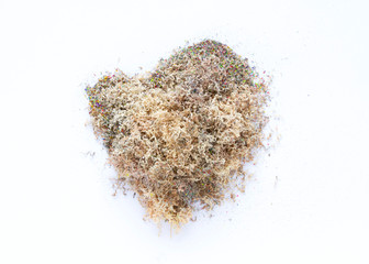 Heap of colour dust from pencils in heart-shaped on white background