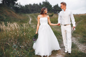 Fototapeta na wymiar Beautiful wedding couple in a summer field