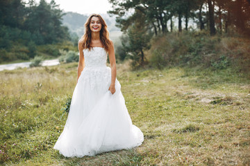 Fototapeta na wymiar Beautiful bride walking in a summer field
