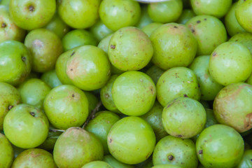 Indian gooseberry (Phyllanthus emblica), also known as emblic, emblic myrobalan, myrobalan, Indian gooseberry, Malacca tree, or amla fruit. Emblic fruits for sale in the fruit market, Thailand.