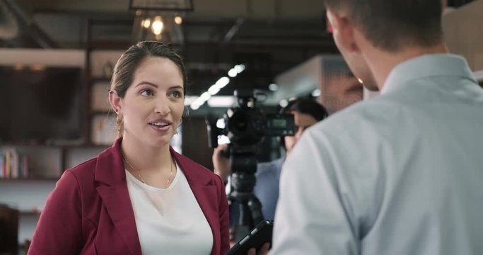 Happy businessman during corporate interview with female journalist at work. Manager answering questions in office. Young woman working as media TV reporter with business man. People, job, profession