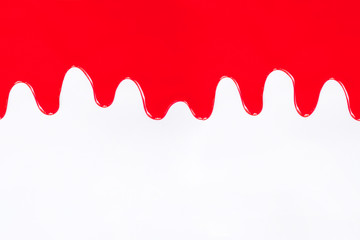 Red paint dripping on a white.