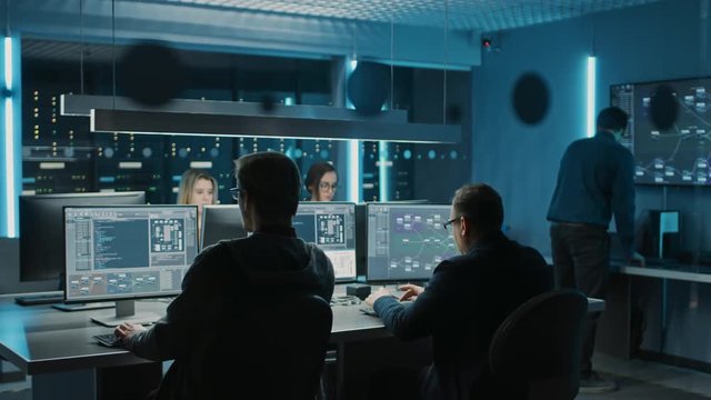 Team of IT Programers Working on Desktop Computers in Data Center Control Room. Young Professionals Writing on Sophisticated Programming Code Language. Elevated Moving Camera Shot