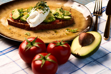 Fresh Avocado Toast and Poached Egg with Baked Tomatoes, close-up
