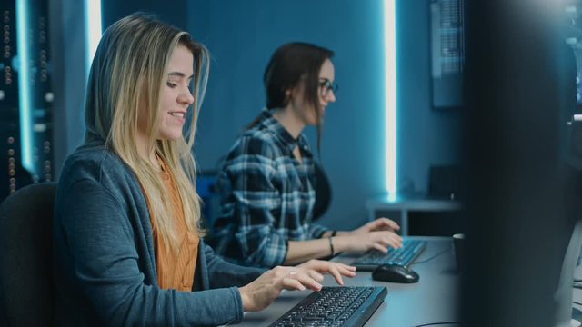 Two Female IT Programers Working on Desktop Computer in Data Center System Control Room. Team of Young Professionals In Software and Hardware Development, Doing Coding
