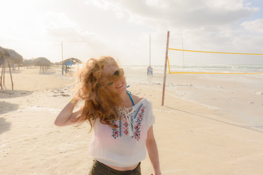 Joven mujer en la playa despeinada por el viento 