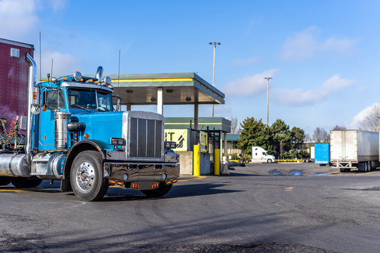 Day Cab Vintage Big Rig Blue Semi Truck With Semi Trailer Moving On Truck Stop With Fuel Station