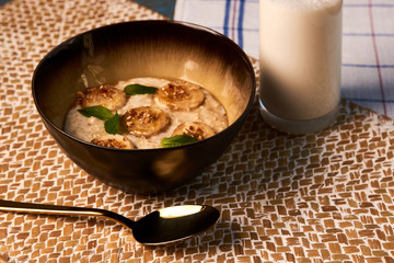 Breakfast oatmeal porridge bowl with banana and caramel, close-up