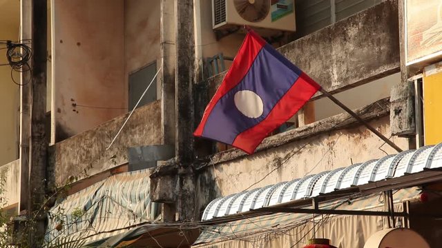 MS Flag of Laos on dilapidated building / Vientiane, Laos