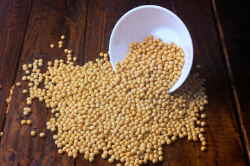 raw and fresh soy beans inside white ceramic bowl on rustic wooden table. Close up