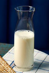 Fresh milk bottle on wooden table, rustic style