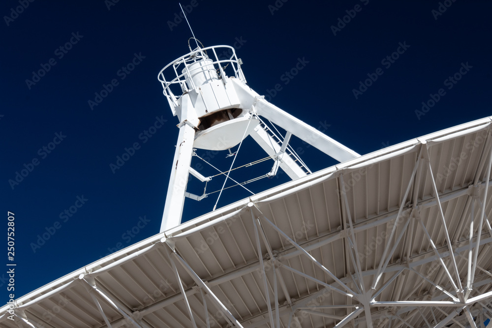 Poster very large array close view of underside of a radio antenna dish vla against a deep blue sky, space 