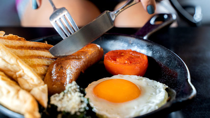 English breakfast: fried egg, bacon, sausage and toast in pan.
