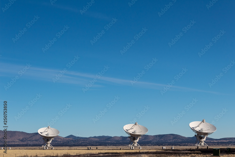 Wall mural very large array three very large radio telescope dishes in the new mexico desert, winter, copy spac