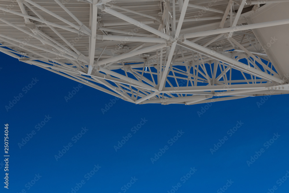 Poster very large array understructure of a large radio telescope dish with blue sky below, creative copy s