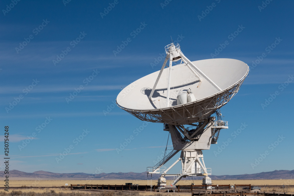Wall mural very large array vla radio antenna dish against a blue sky in the new mexico desert, technology spac