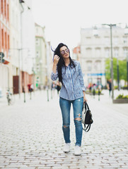 Young brunette woman walking and relaxing in old city street